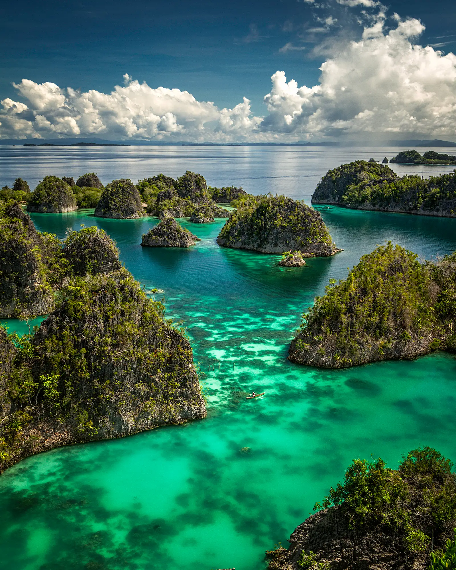 Aerial view over the Piaynemo karst lagoon, dozens of steep green islets in turquoise shallows