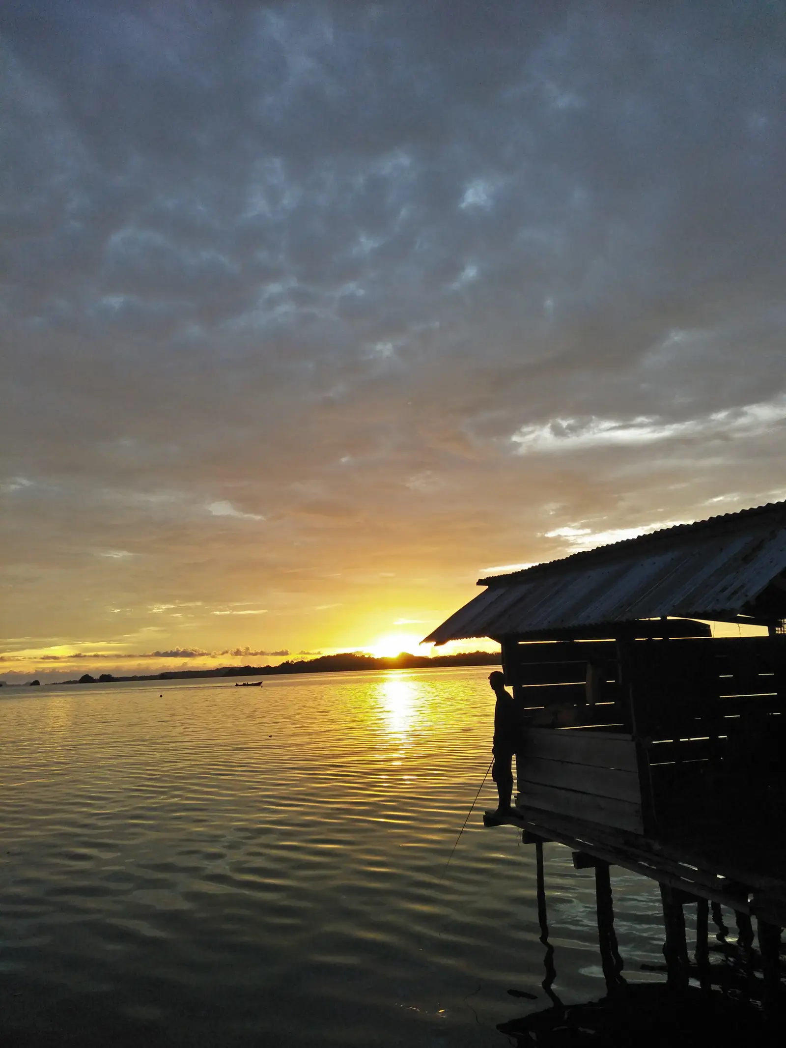 Sunset over the water from a shoreline building in southern Misool