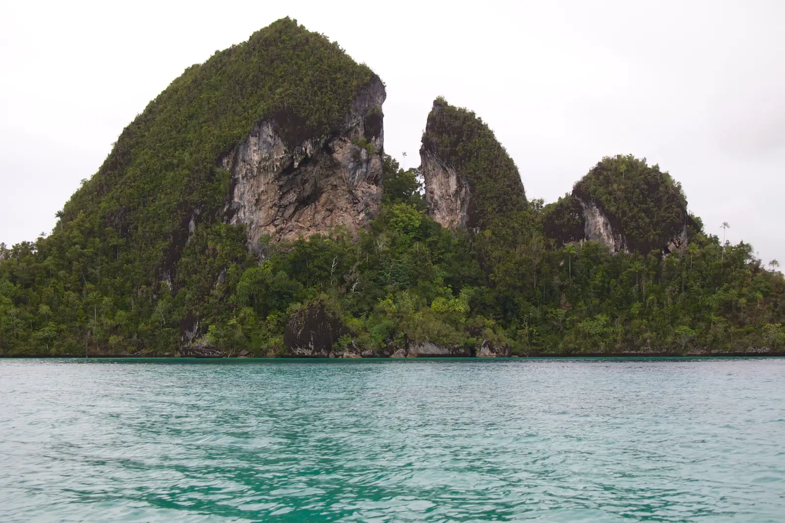 A large karst island standing in open water at Wayag
